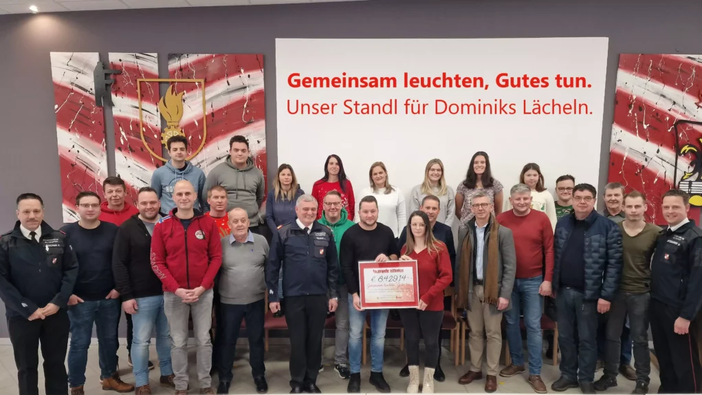 Foto in Beitrag von 5min.at: Zu sehen sind viele Menschen bei der Übergabe des Spendenschecks.