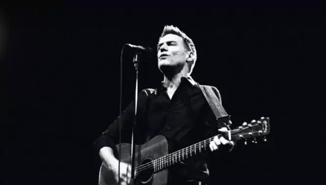 Das Bild auf 5min.at zeigt Musiker Bryan Adams bei einem Auftritt auf der Bühne.