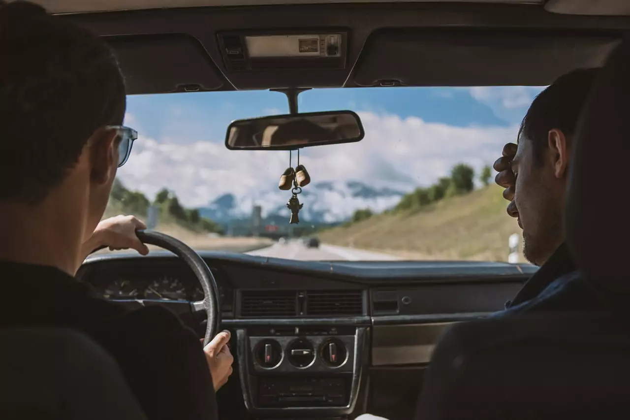 Ein Bild auf 5min.at zeigt zwei Freunde bei einem Roadtrip. Sie sitzen gerade in einem Auto.