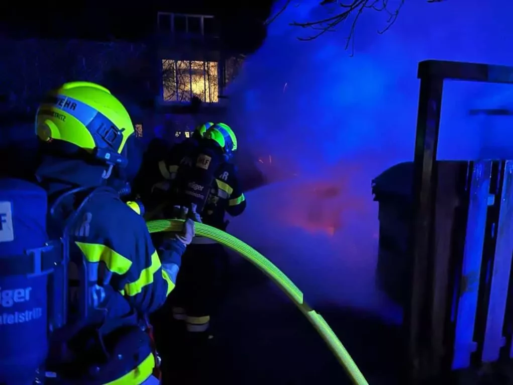Müllinsel in Vollbrand: Feuerwehr mit schwerem Atemschutz im Einsatz
