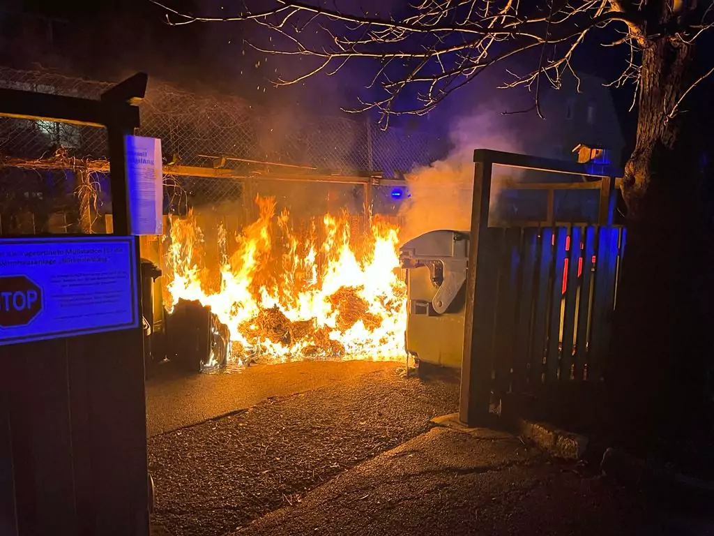 Müllinsel in Vollbrand: Feuerwehr mit schwerem Atemschutz im Einsatz