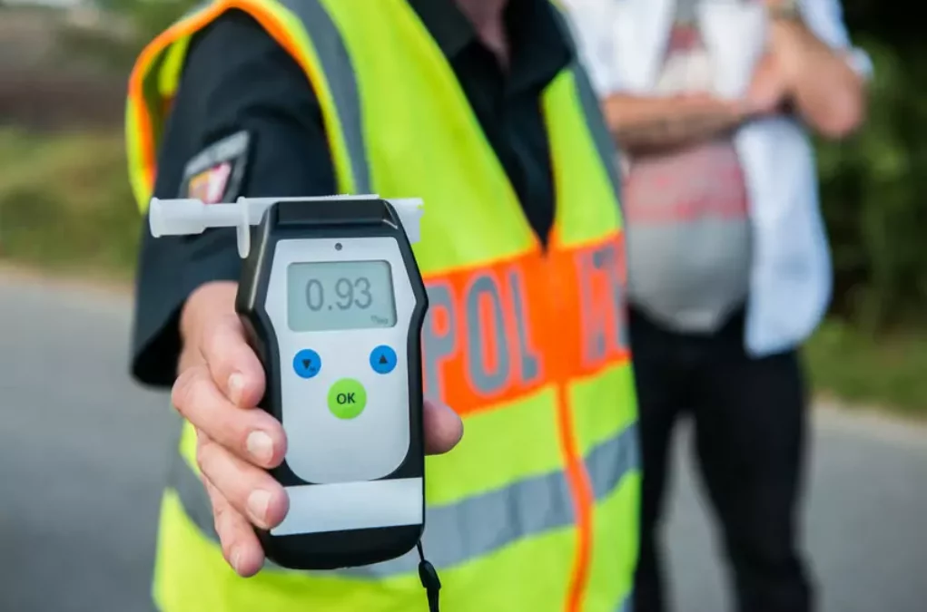 Foto in Beitrag von 5min.at: Zu sehen ist eine Person, die ein Alkoholgerät in der Hand hält, um den Wert im Atem zu messen.