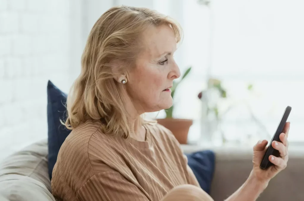 Symbolfoto auf 5min.at zeigt eine ältere Frau mit einem Handy in der Hand.