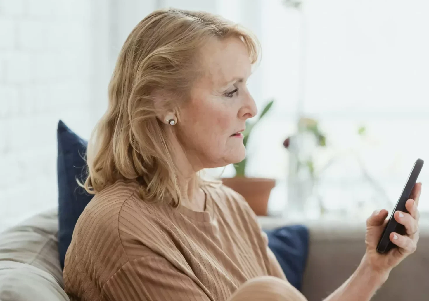Symbolfoto auf 5min.at zeigt eine &auml;ltere Frau mit einem Handy in der Hand.