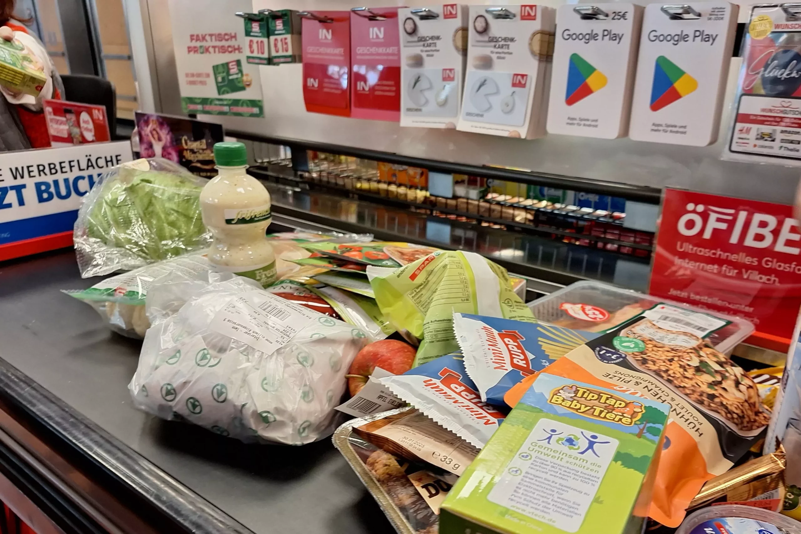 Ein Bild auf 5min.at zeigt Lebensmittel auf dem Kassenband eines Supermarktes.