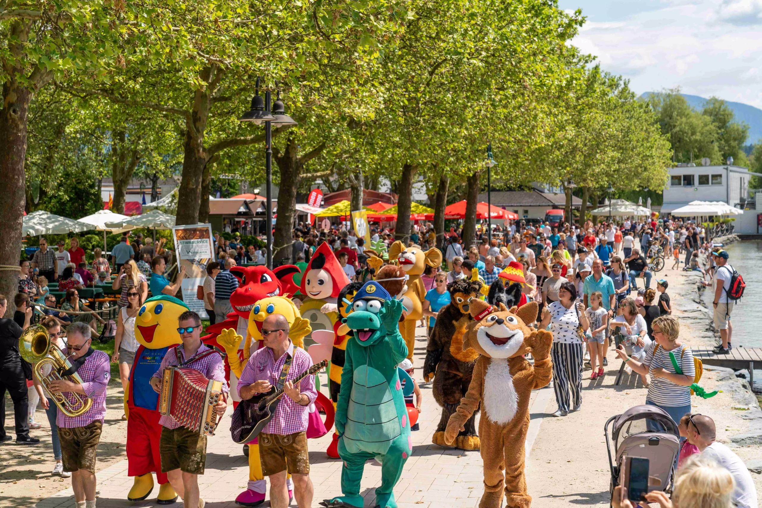 Das Bild auf 5min.at zeigt eine Parade mit Maskottchen.