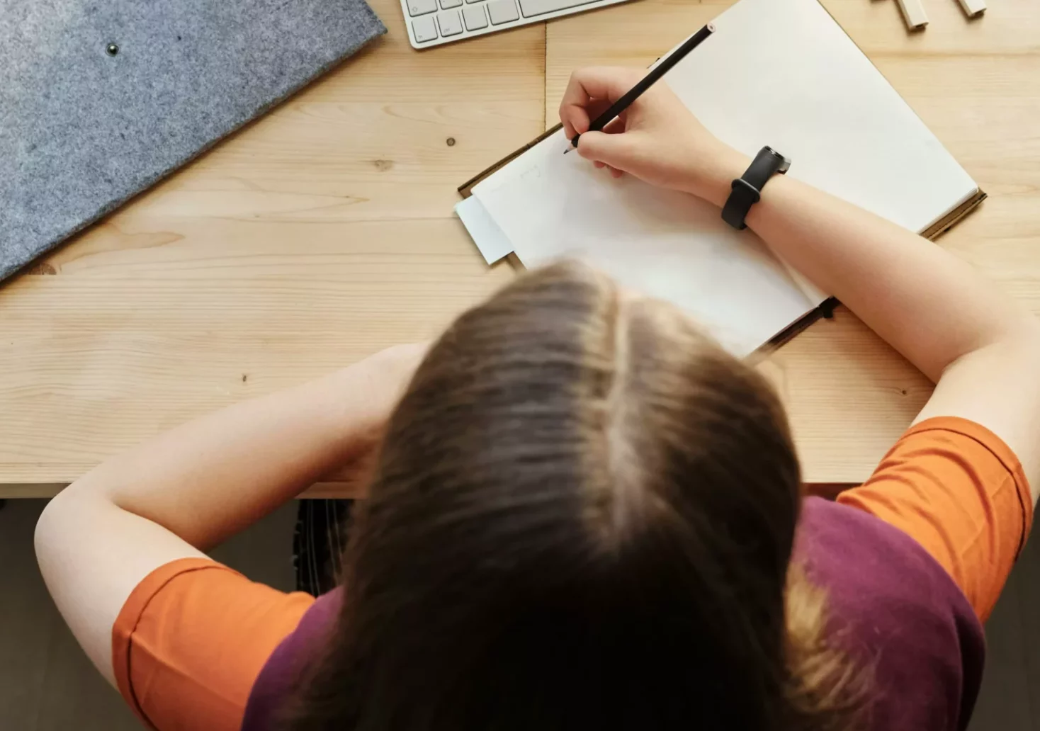 Das Bild auf 5min.at zeigt ein Mädchen, das bei einem Schreibtisch sitzt.