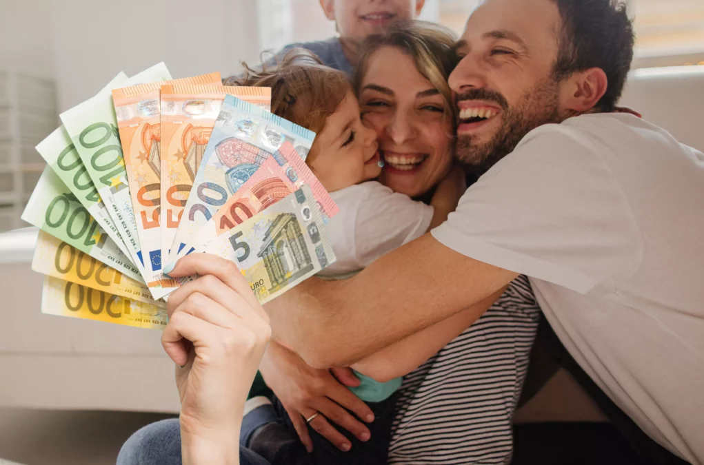 Symbolfoto auf 5min.at zeige eine Familie mit Geld im Vordergrund.
