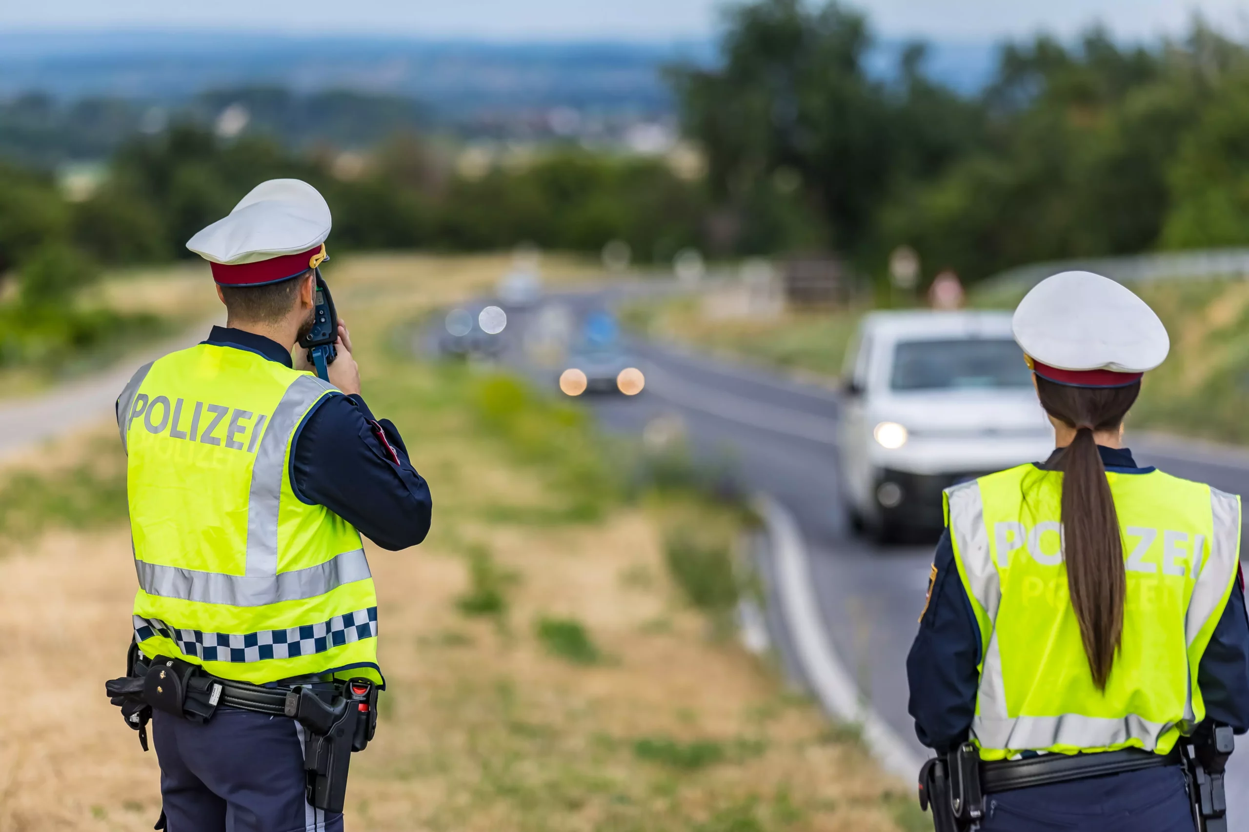 Foto in Beitrag von 5min.at: Zu sehen sind zwei Polizisten, die den Verkehr kontrollieren und Geschwindigkeit messen.