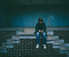 Ein Bild auf 5min.at zeigt einen Bub der auf einer Treppe sitzt