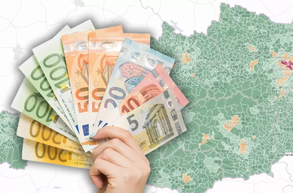 Bild auf 5min.at zeigt eine &Ouml;sterreich-Karte, im Vordergrund ist eine Hand mit Geldscheinen zu sehen.