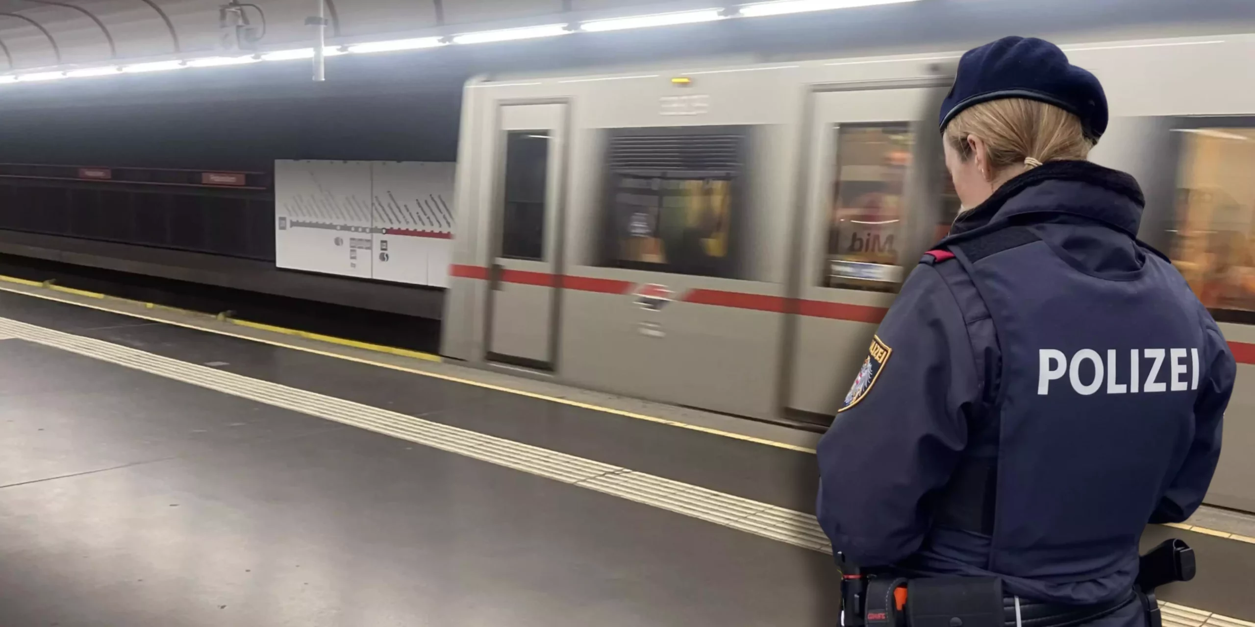 Ein Bild auf 5min.at zeigt eine Polizistin vor der U-Bahn.