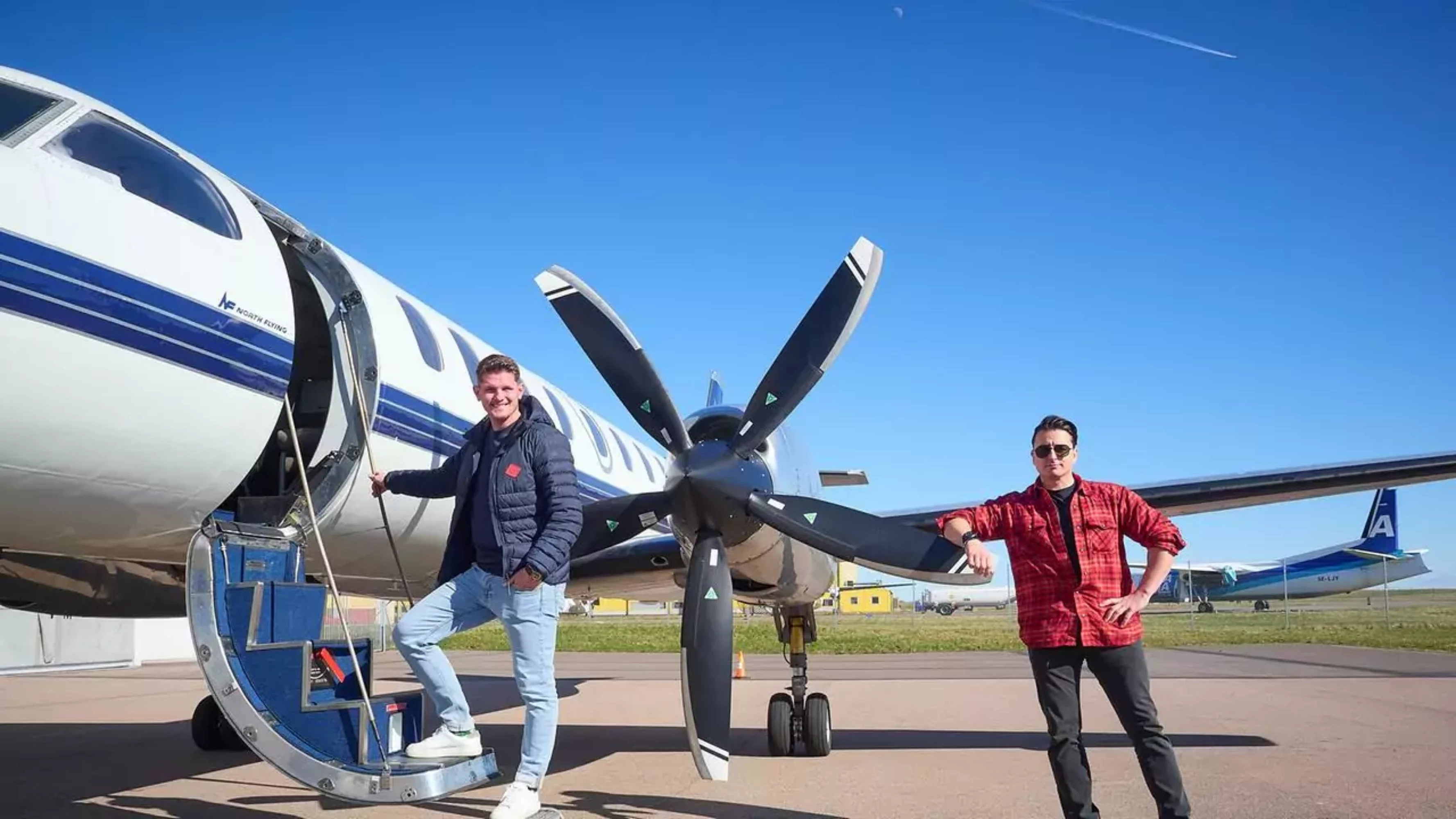 Bild auf 5min.at zeigt zwei Männer bei einem Flugzeug.