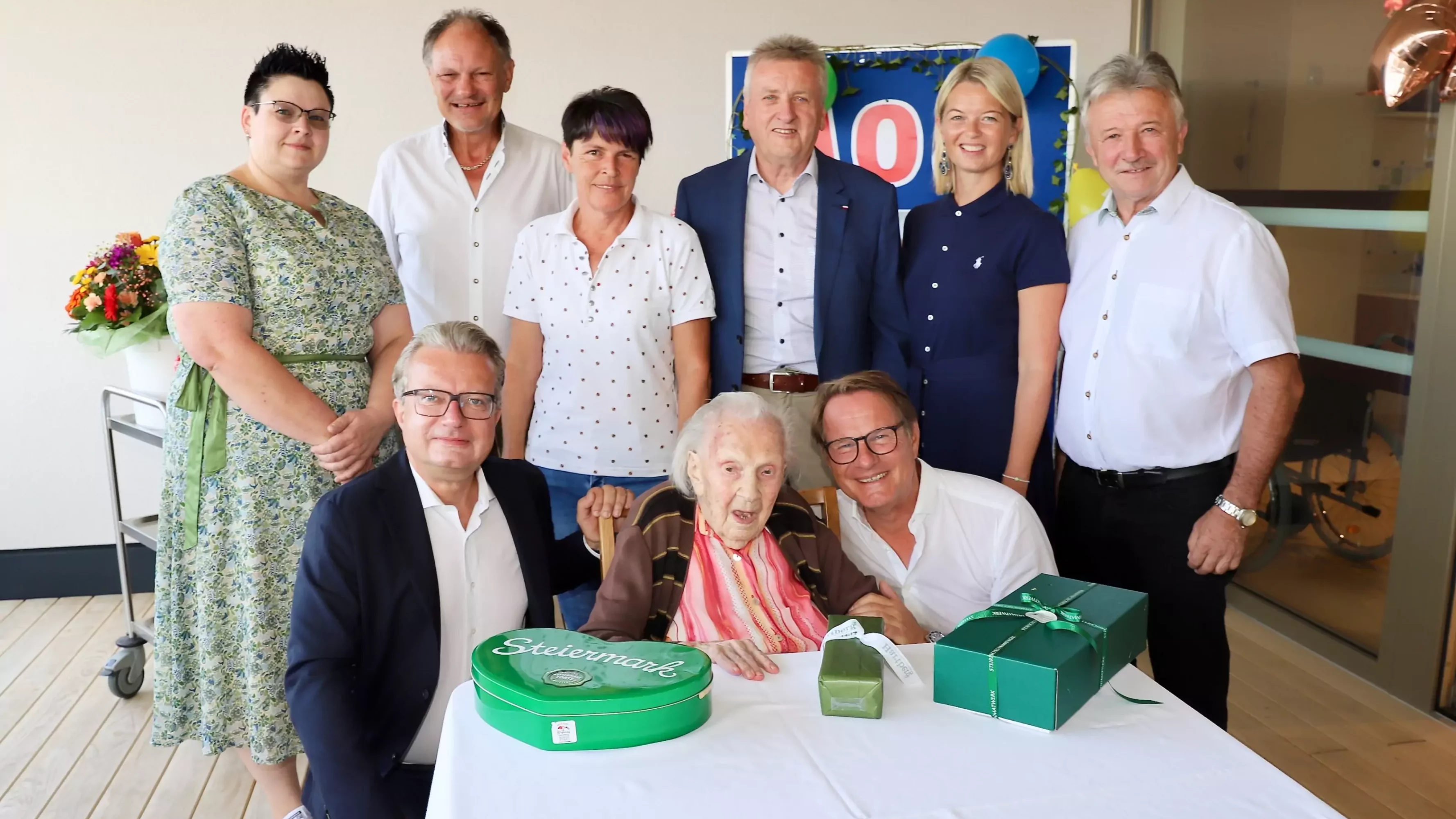 Erika Strohrigel feiert ihren 108. Geburtstag im Beisein von LH Christopher Drexler (vorne l.), Bürgermeister Marcus Martschitsch (vorne r.) sowie dem Landtagsabgeordneten Hubert Lang, BH Kerstin Raith-Schweighofer, Herbert Spirk, Alexandra Peinsipp und Johann Fuchs (hinten v.r.)
