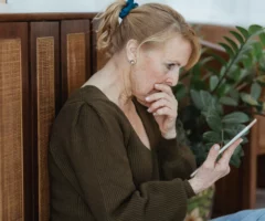 Ein Bild auf 5min.at zeigt eine schockierte Frau, die in ihr Handy schaut.