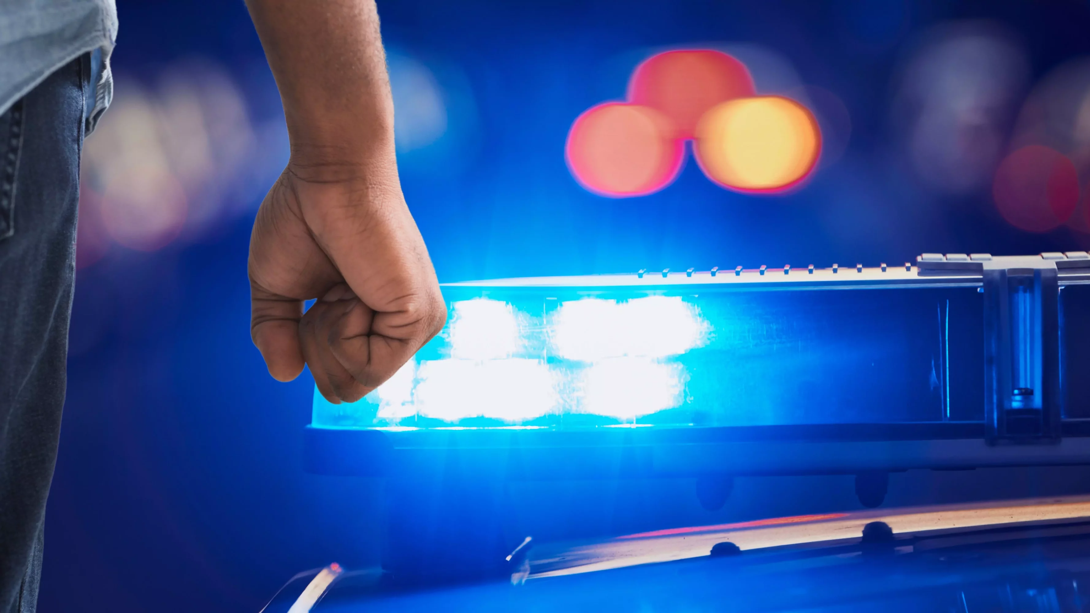 Ein Bild auf 5min.at zeigt das Blaulicht der Polizei und die Faust eines Mannes.