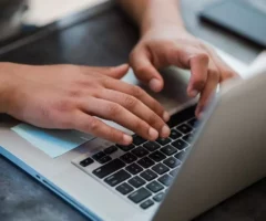 Ein Bild auf 5min.at zeigt H&auml;nde und einen Laptop.