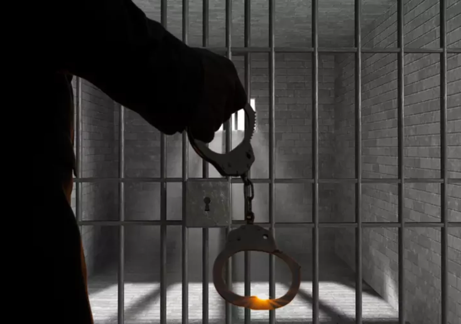 Das Bild auf 5min.at zeigt eine Silhouette mit Handschellen vor einer Gefängniszelle.