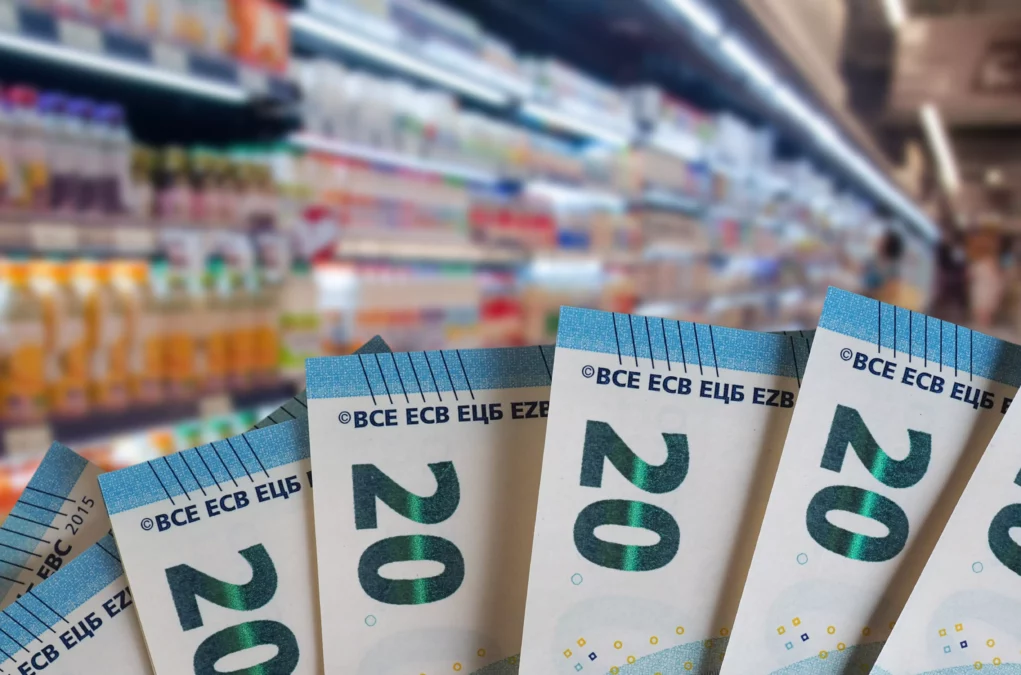 Eine Bildmontage auf 5min.at zeigt 20 Euro Scheine vor einem Supermarktregal.