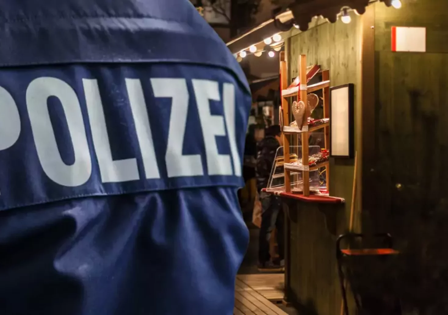 Foto auf 5min.at zeigt eine Bildmontage von einer Weihnachtsmarkt-Hütte und einem Polizisten von hinten.
