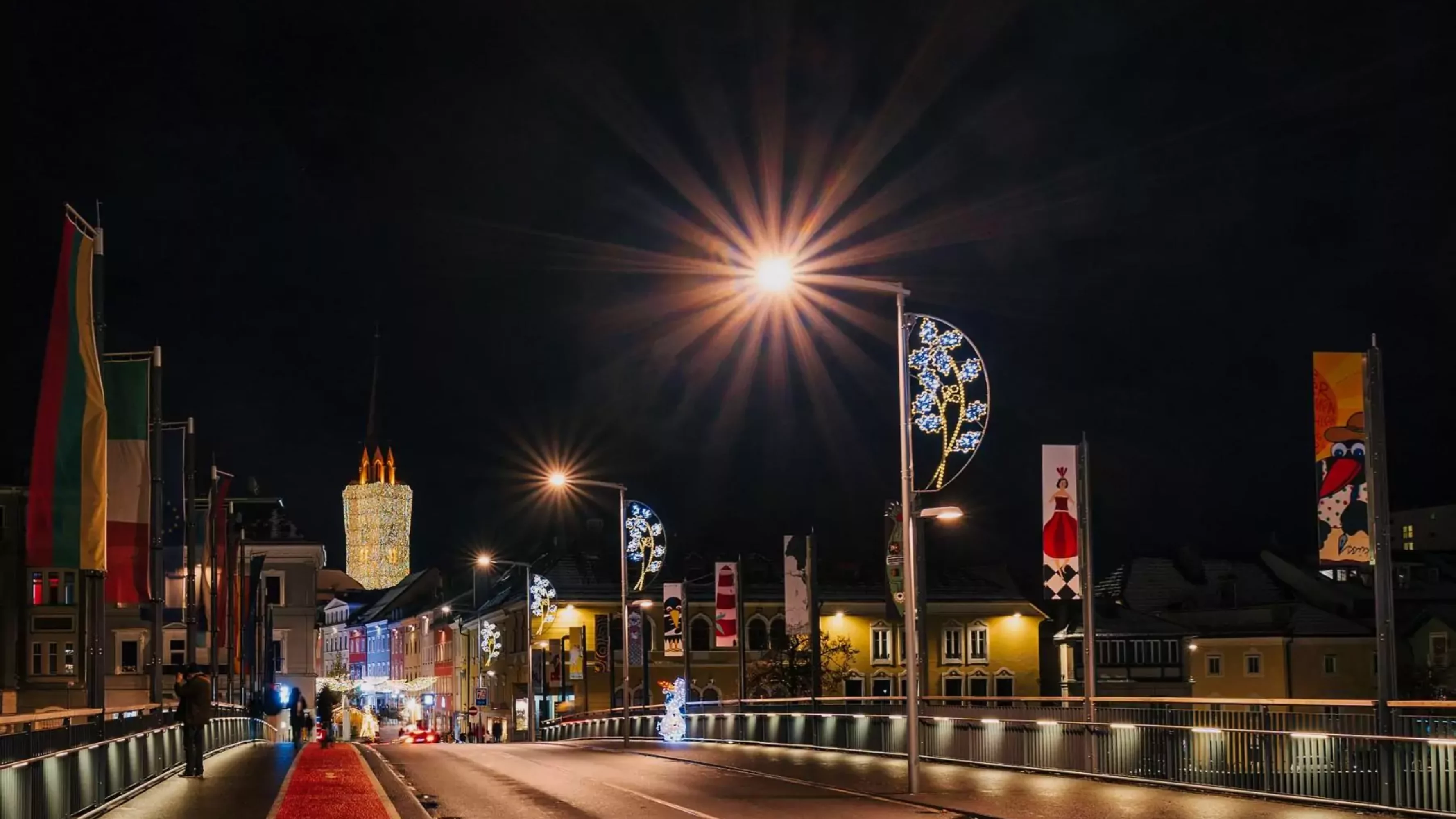 Ein Bild auf 5min.at zeigt die Draubrücke in Villach mit festlicher Weihnachtsbeleuchtung.