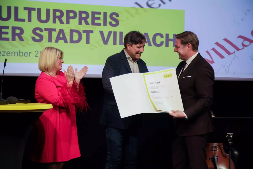 Das Bild auf 5min.at zeigt Michael Kos freute sich sehr über die Zuerkennung des Villacher Kulturpreis, den Bürgermeister Günther Albel und Vizebürgermeisterin Gerda Sandriesser überreichten.