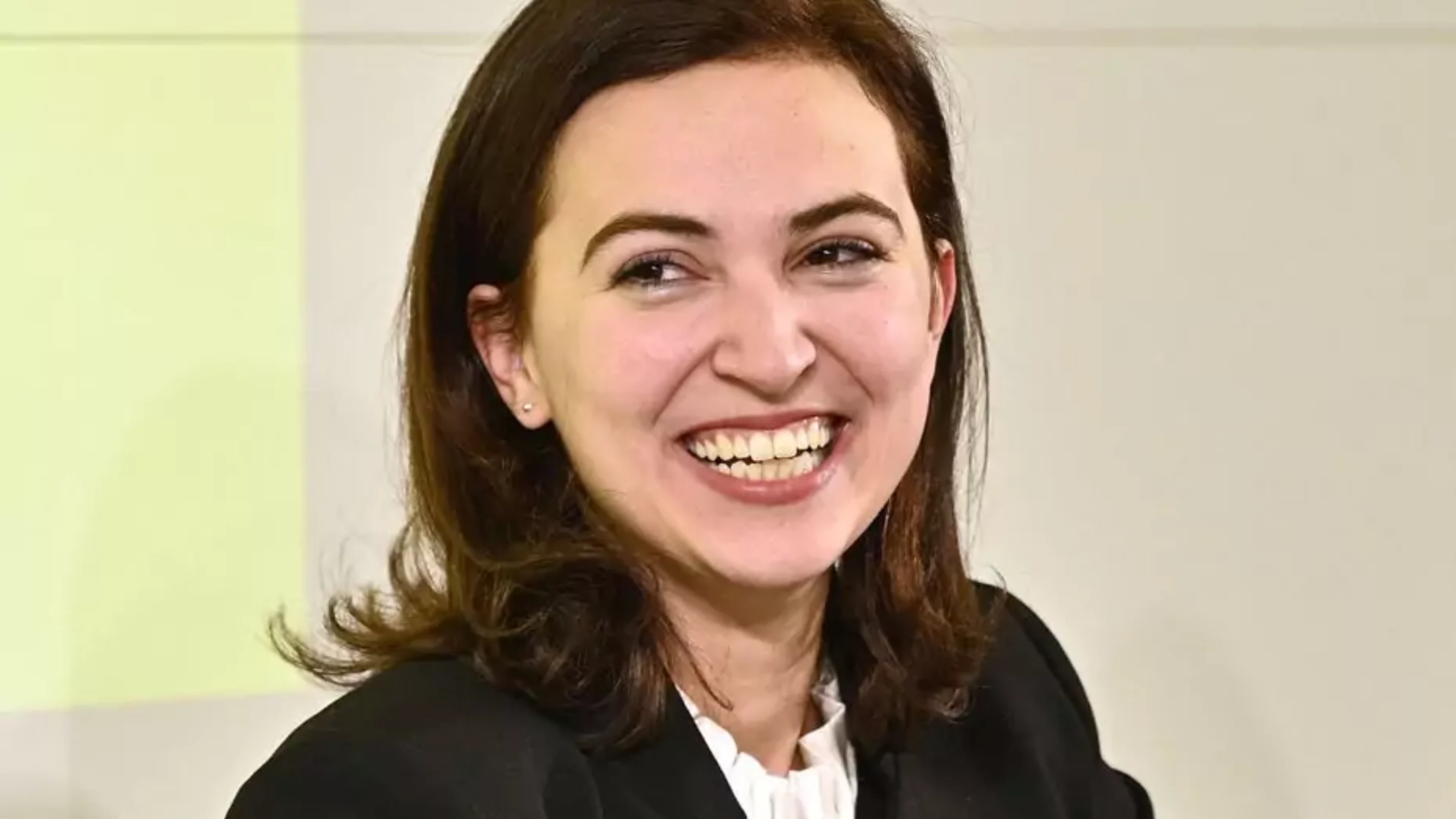 Ein Bild auf 5min.at zeigt die österreichische Justizministerin Alma Zadić mit einem Lächeln.