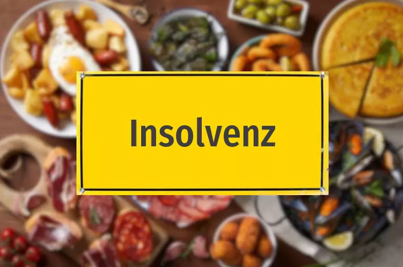 Das Bild auf 5min.at zeigt ein Insolvenzschild vor einem Hintergrund mit viel Essen.