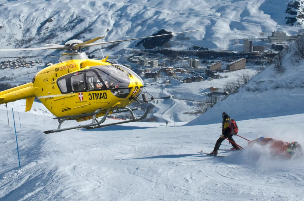 Foto auf 5min.at zeigt eine verletzte Skifahrerin auf der Piste und einen Rettungshubschrauber.