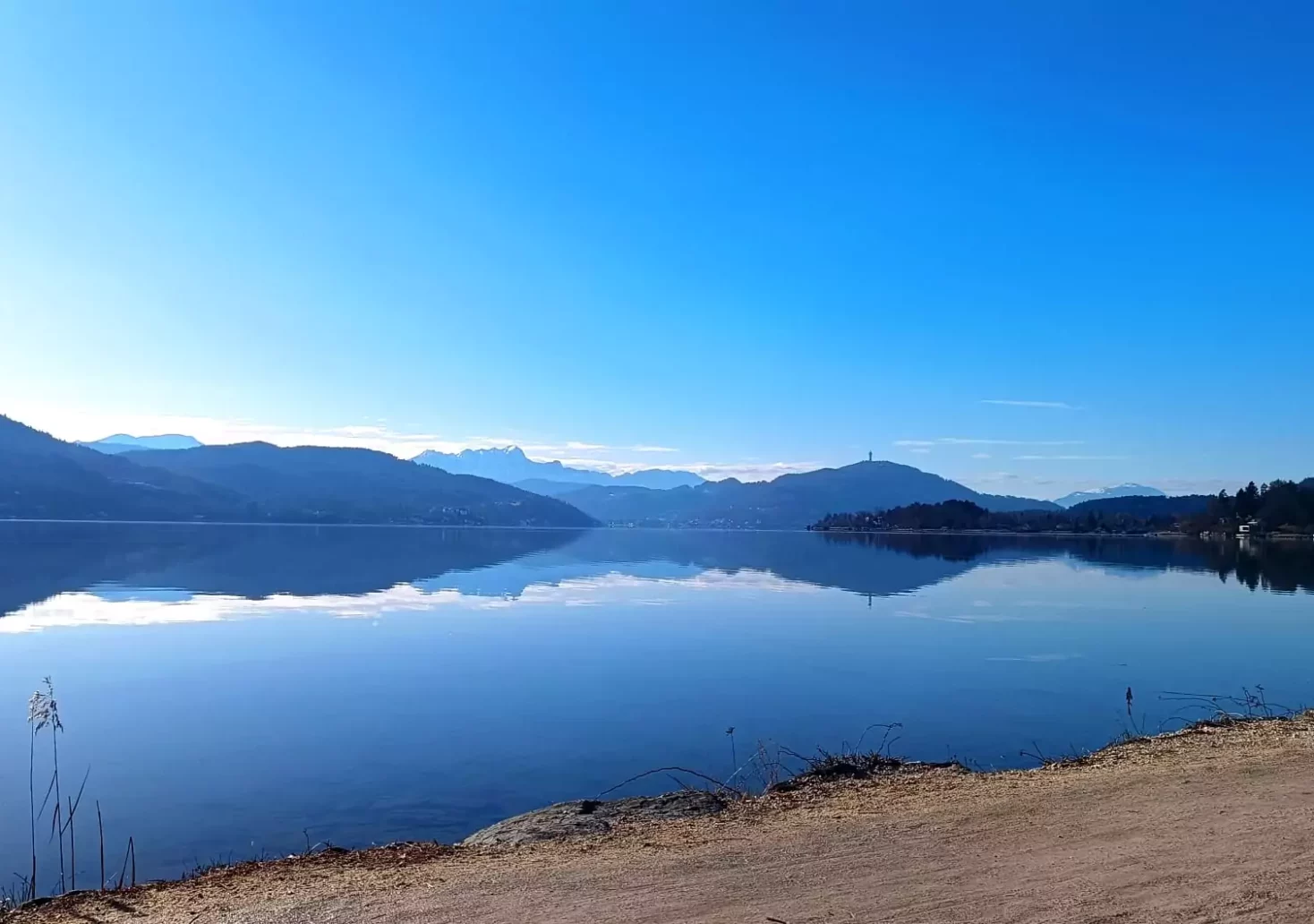 Ein Bild auf 5min.at zeigt den blauen Himmel über dem Wörthersee in Klagenfurt. In der Ferne ist der Pyramidenkogel zu sehen.