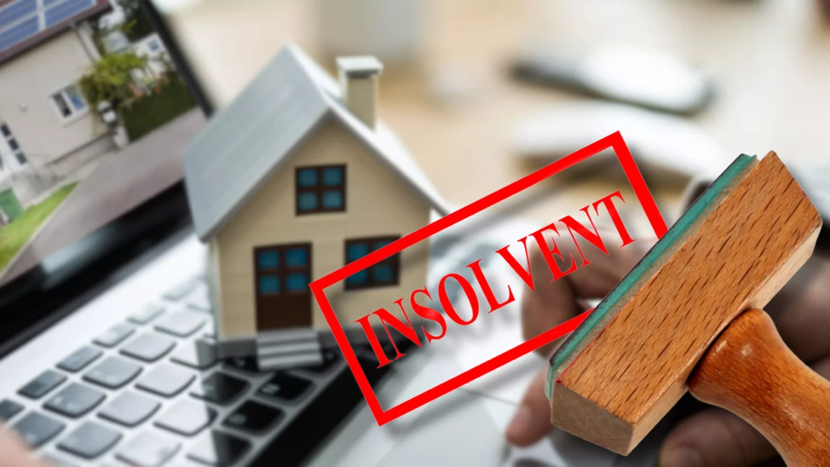 Foto in Beitrag von 5min.at zeigt einen Insolvenz-Stempel, ein Haus und einen Laptop.