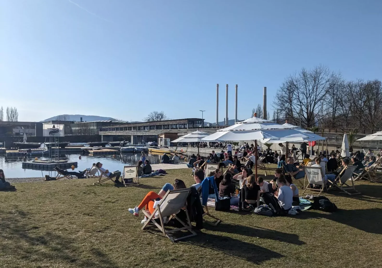 Bild auf 5min.at zeigt Personen, die bei einem Fluss sitzen.