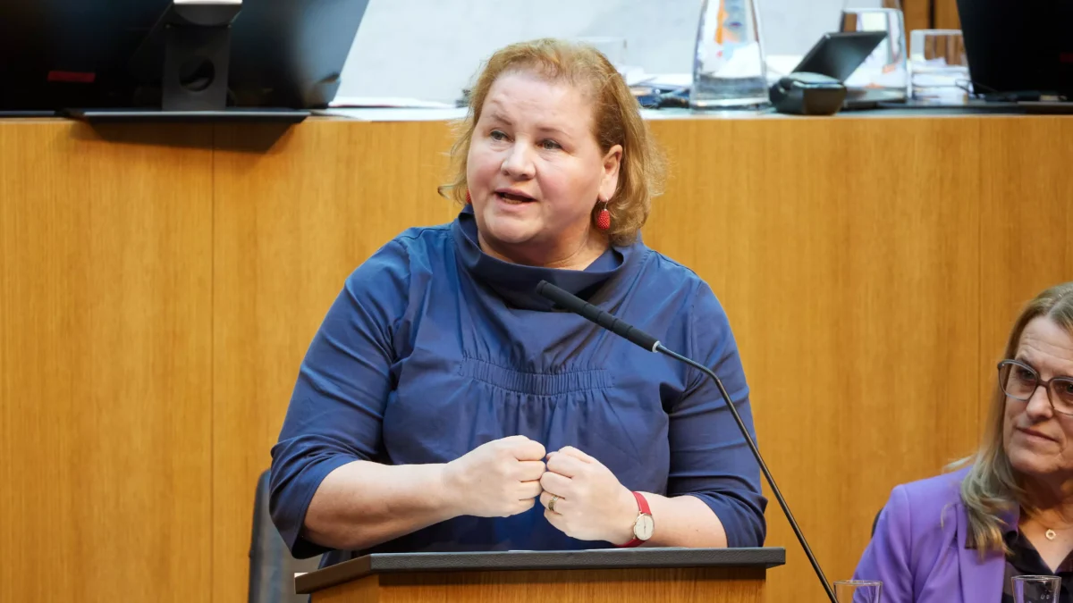 Foto in Bericht von 5min.at: Zu sehen ist Sozialministerin Korinna Schumann bei einer Parlamentssitzung vor einem Rednerpult.