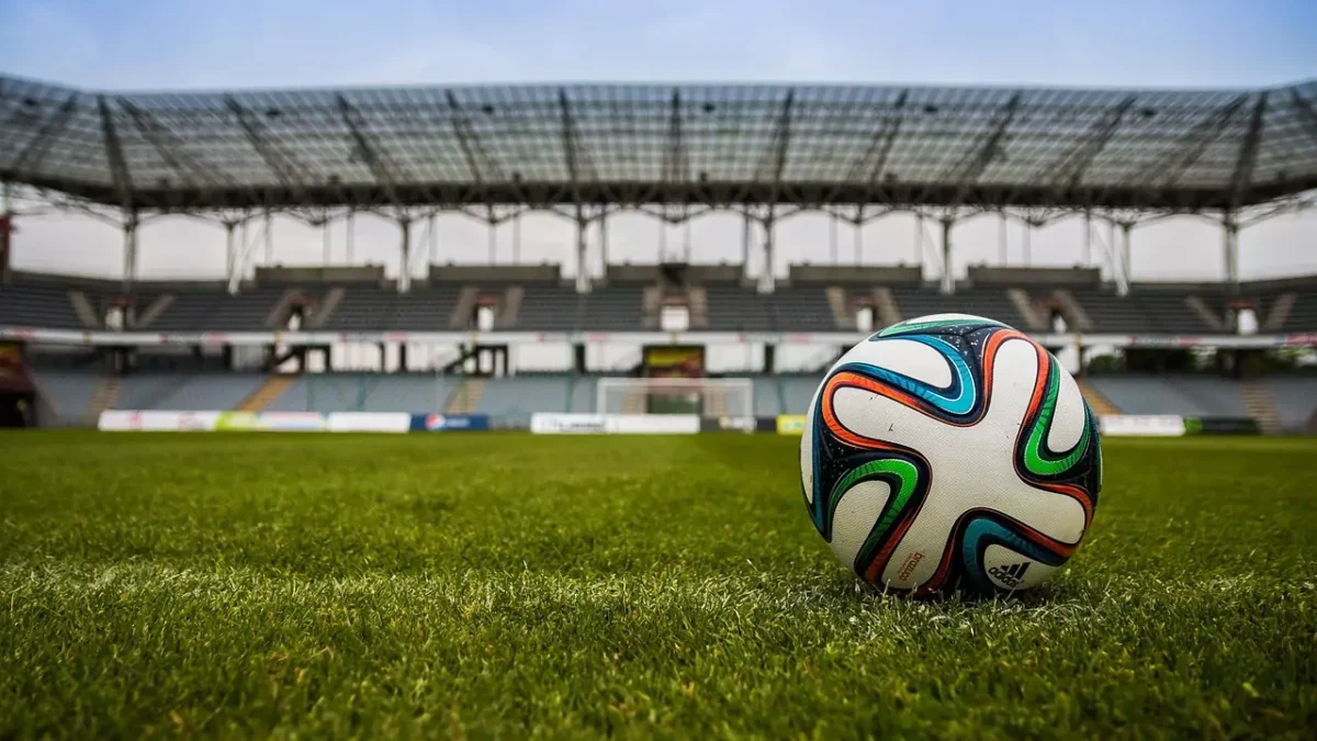 Das Bild auf 5min.at zeigt einen Fußball und ein Fußballstadion.