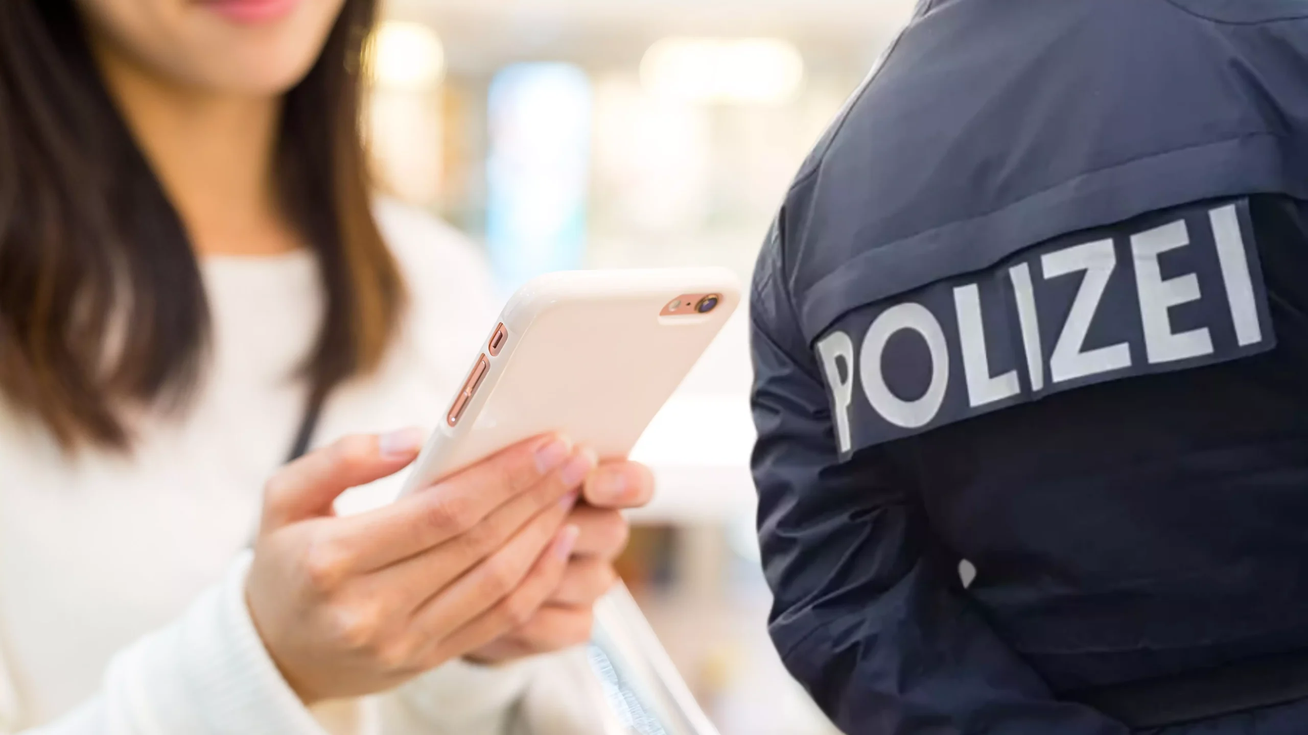Eine Bildmontage auf 5min.at zeigt eine Frau, die auf ein Smartphone schaut sowie einen Polizeibeamten.