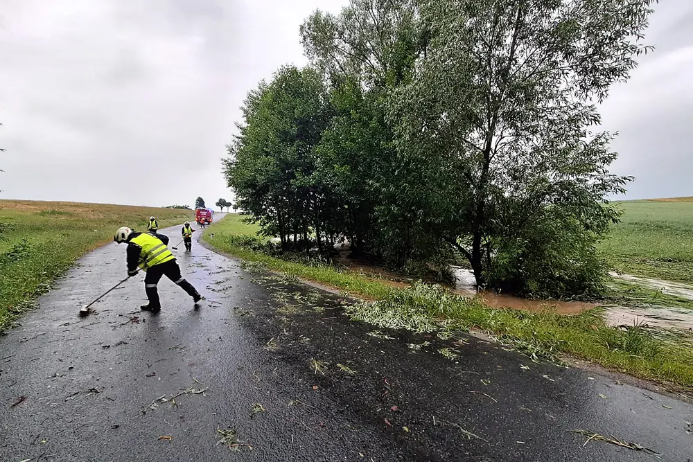 Ein Bild auf 5min.at zeigt die Feuerwehr beim Fegen einer Straße nach dem Unwetter.