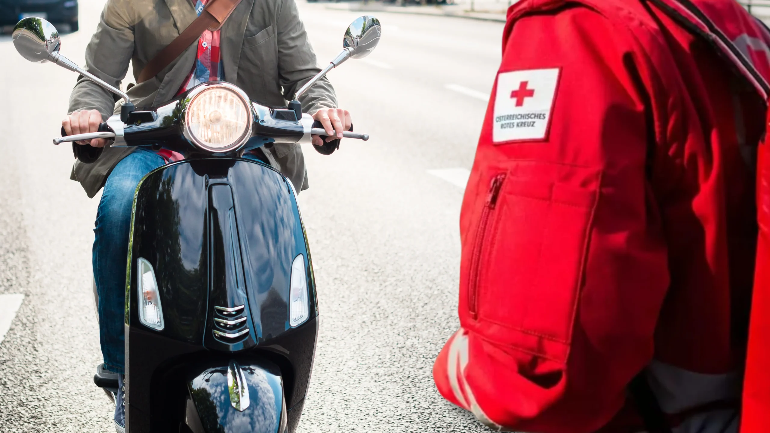 Ein Bild auf 5min.at zeigt einen Mopedfahrer und einen Mitarbeiter des Roten Kreuz.