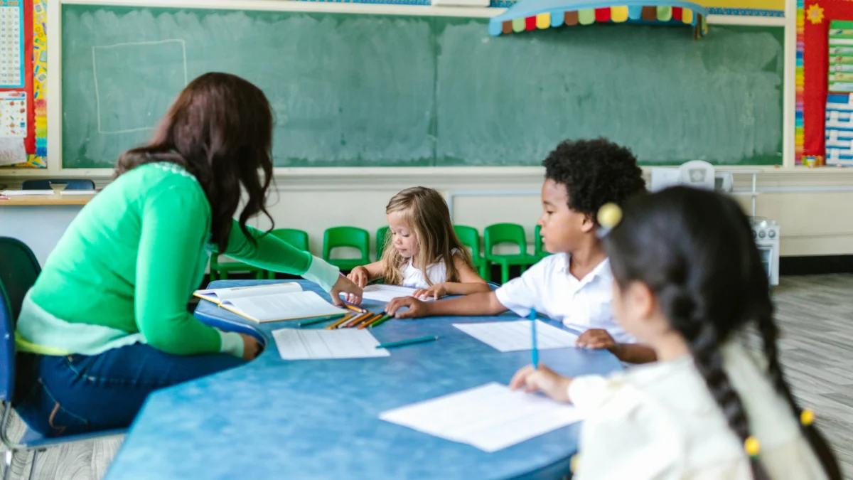Symbolfoto auf 5min.at zeigt eine Lehrerin mit Schülern.