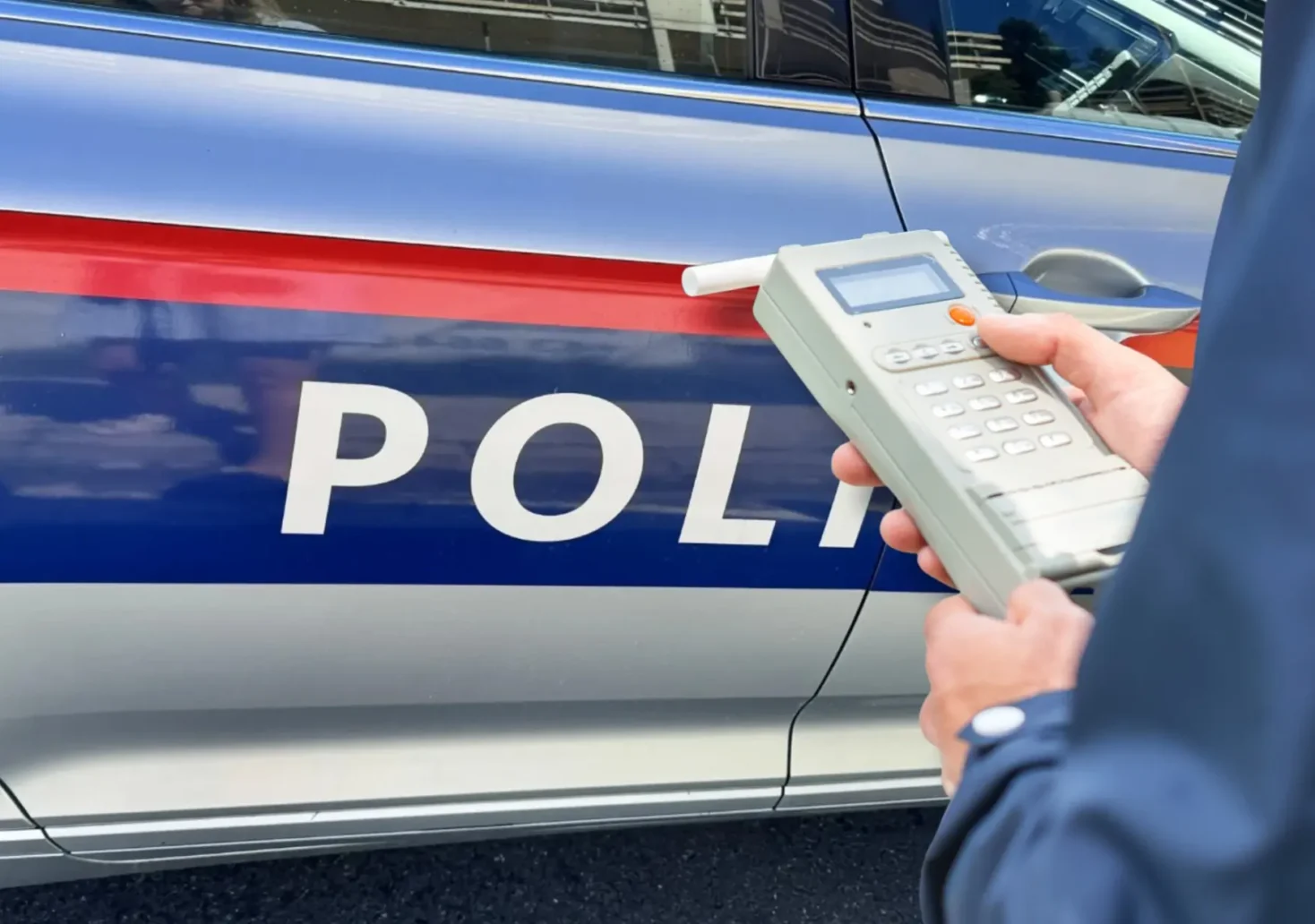 Eine Bildmontage auf 5min.at zeigt ein Polizeiauto sowie einen Polizisten, der einen Alkomattest durchf&uuml;hrt.