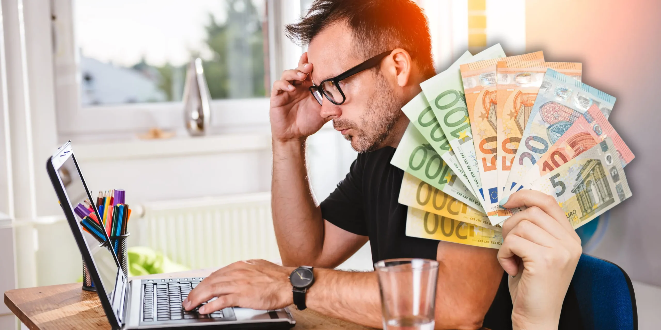 Foto in Beitrag von 5min.at zeigt im Vordergrund eine Hand mit mehreren Euroscheinen, im Hintergrund eine Person vor einem Laptop, der angestrengt auf den Bildschirm schaut.