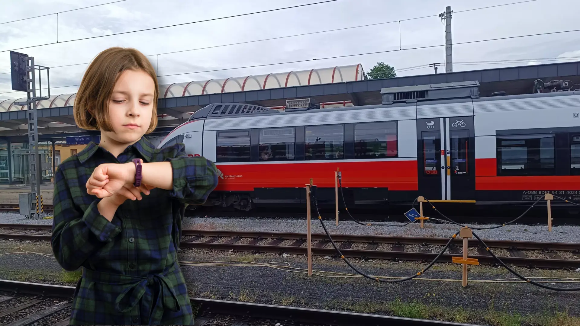 Das Bild auf 5min.at zeigt ein Mädchen, das am Villacher Hauptbahnhof auf die Uhr schaut.