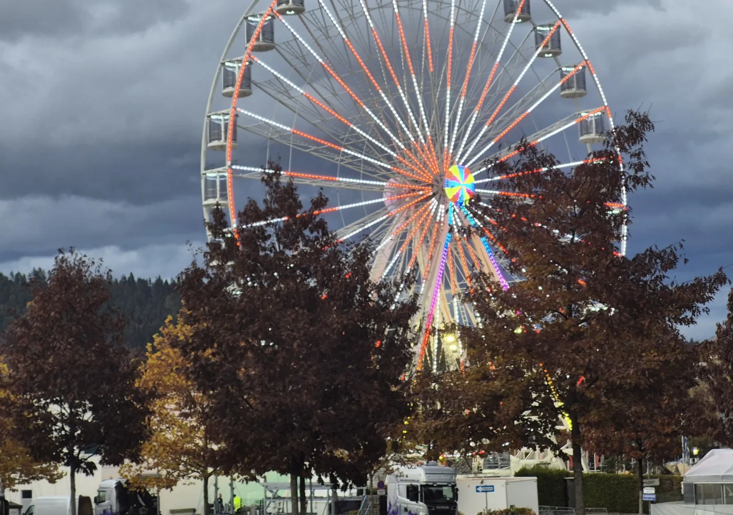 Ein Bild auf 5min.at zeigt das Riesenrad. Unterhalb stehen LKW.