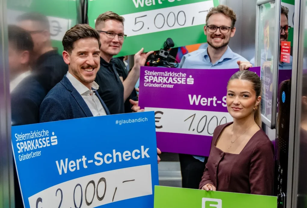 Foto auf 5min.at zeigt Personen in die Kamera lächeln.