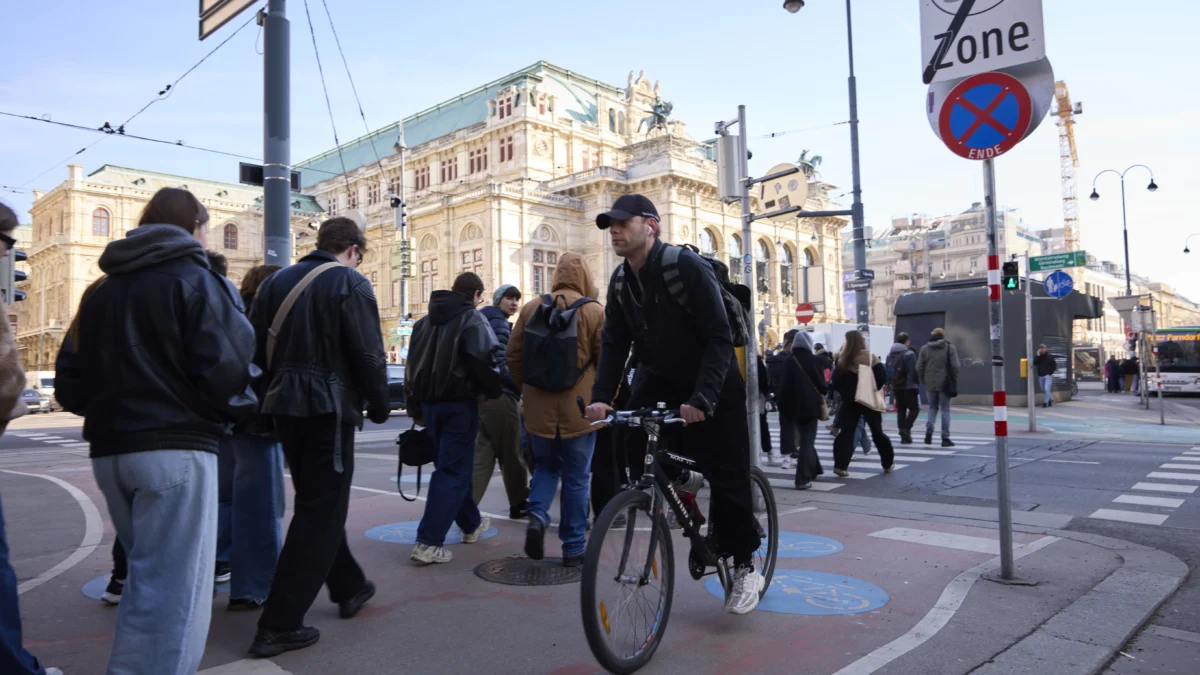 Das Bild auf 5min.at zeigt Radfahrer und Fußgänger, die die Straße überqueren.