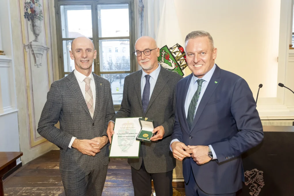 Foto auf 5min.at zeigt drei Personen in die Kamera lächeln.