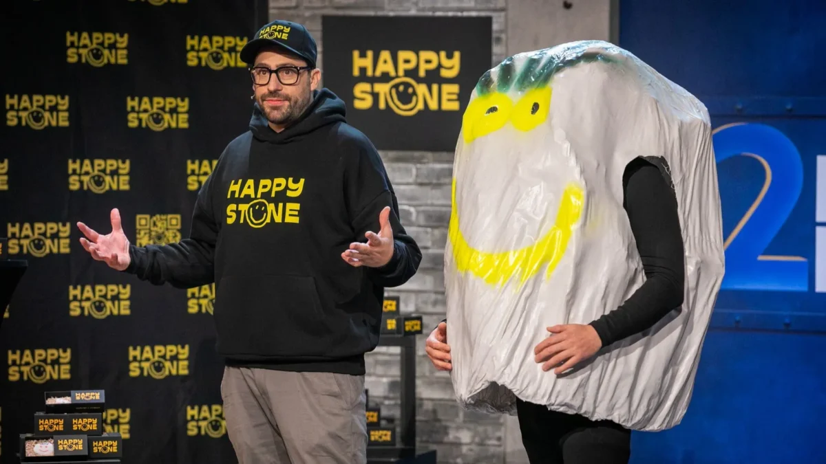 Ein Bild auf 5min.at zeigt Benjamin Keitel und ein Stein-Maskottchen.