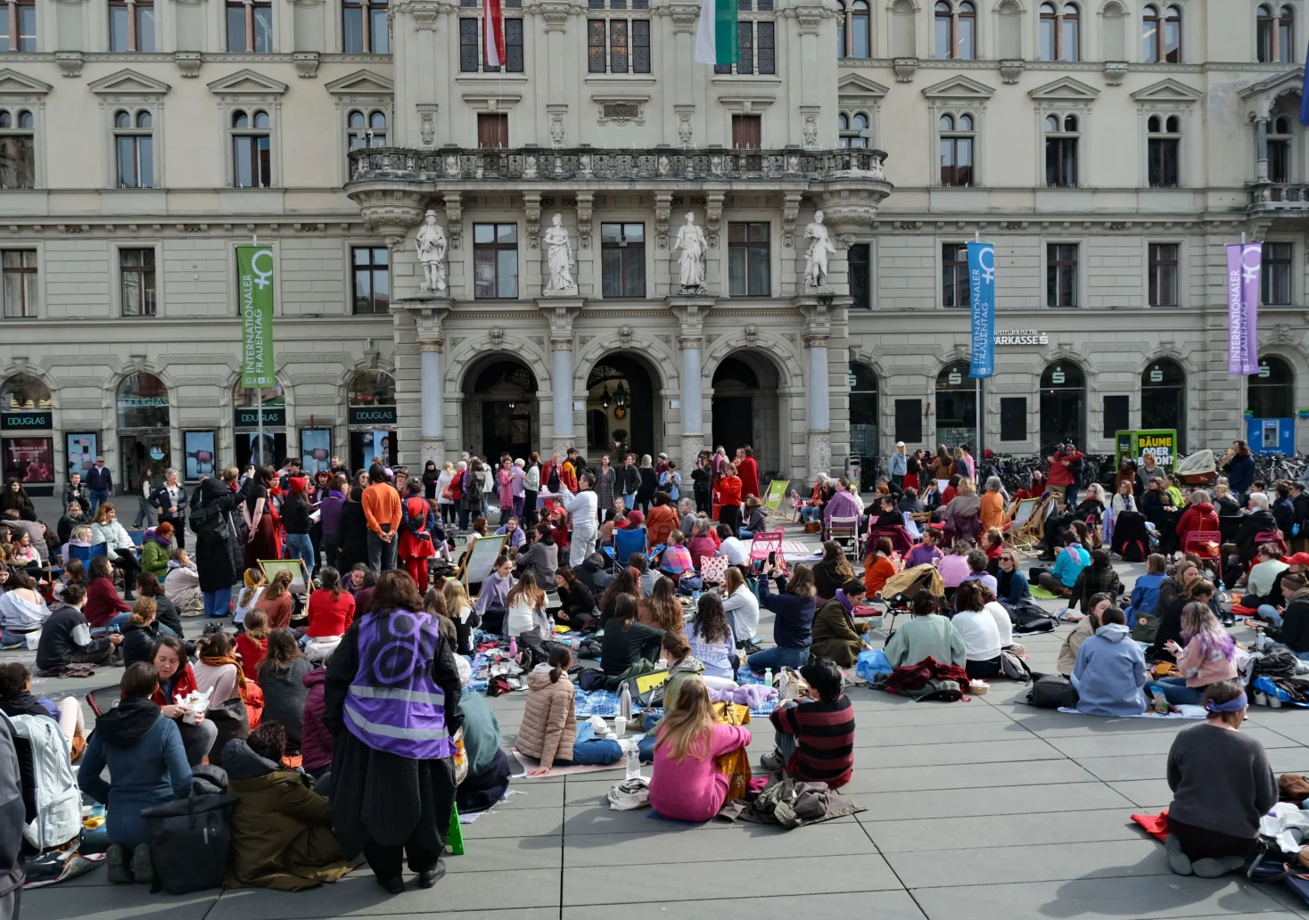 Das Bild auf 5min.at zeigt: Am Montag, dem 9. März 2026, versammelten sich knapp 300 Frauen am Grazer Hauptplatz zum „Nichtstun“.