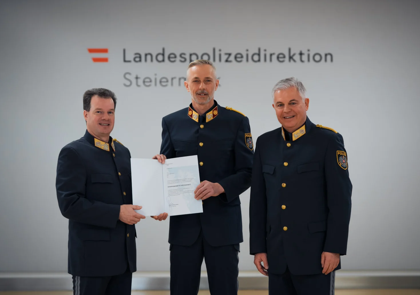 Foto auf 5min.at zeigt drei Männer in die Kamera lächeln.