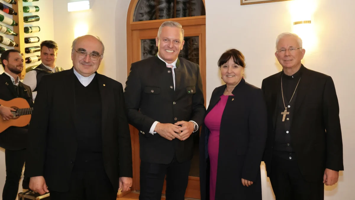 Foto auf 5min.at zeigt mehrere Personen in die Kamera lächeln.