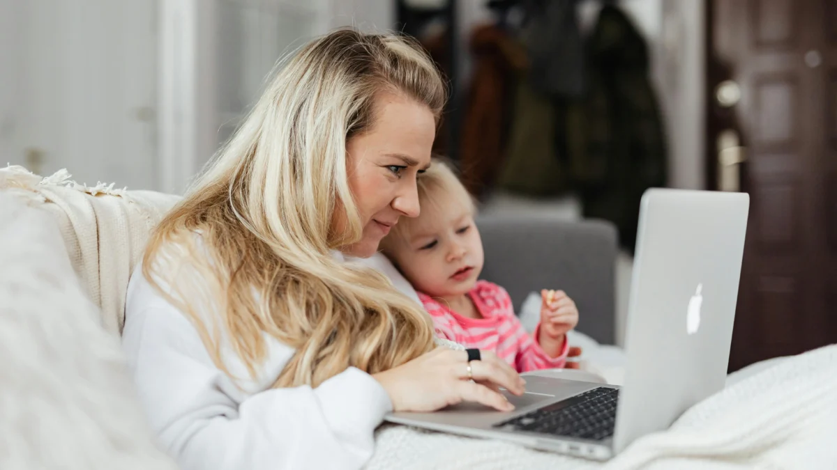 Foto auf 5min.at zeigt eine Frau mit Kleinkind im Homeoffice.